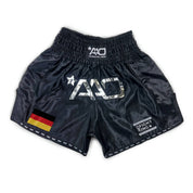 "Vorderansicht Premium Muay Thai Shorts im Deutschland Flaggen-Design aus glänzendem Micro-Satin für Wettkampf und Training."