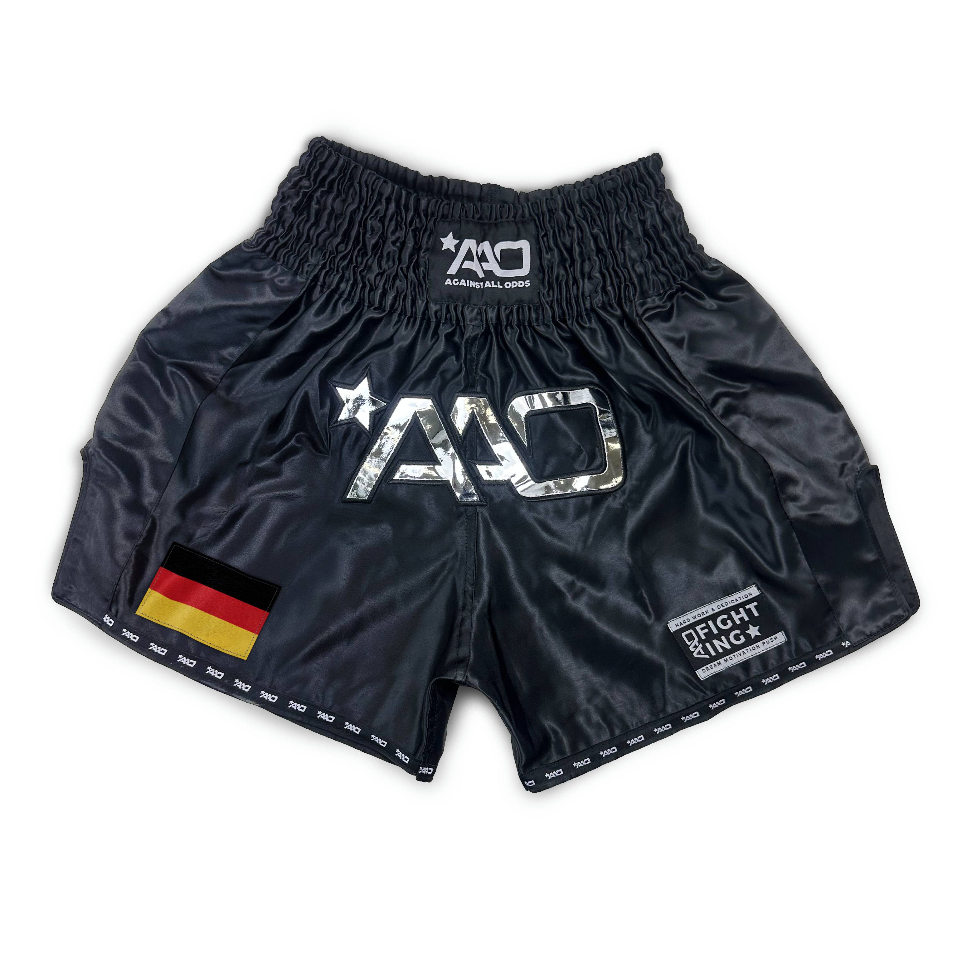 "Vorderansicht Premium Muay Thai Shorts im Deutschland Flaggen-Design aus glänzendem Micro-Satin für Wettkampf und Training."